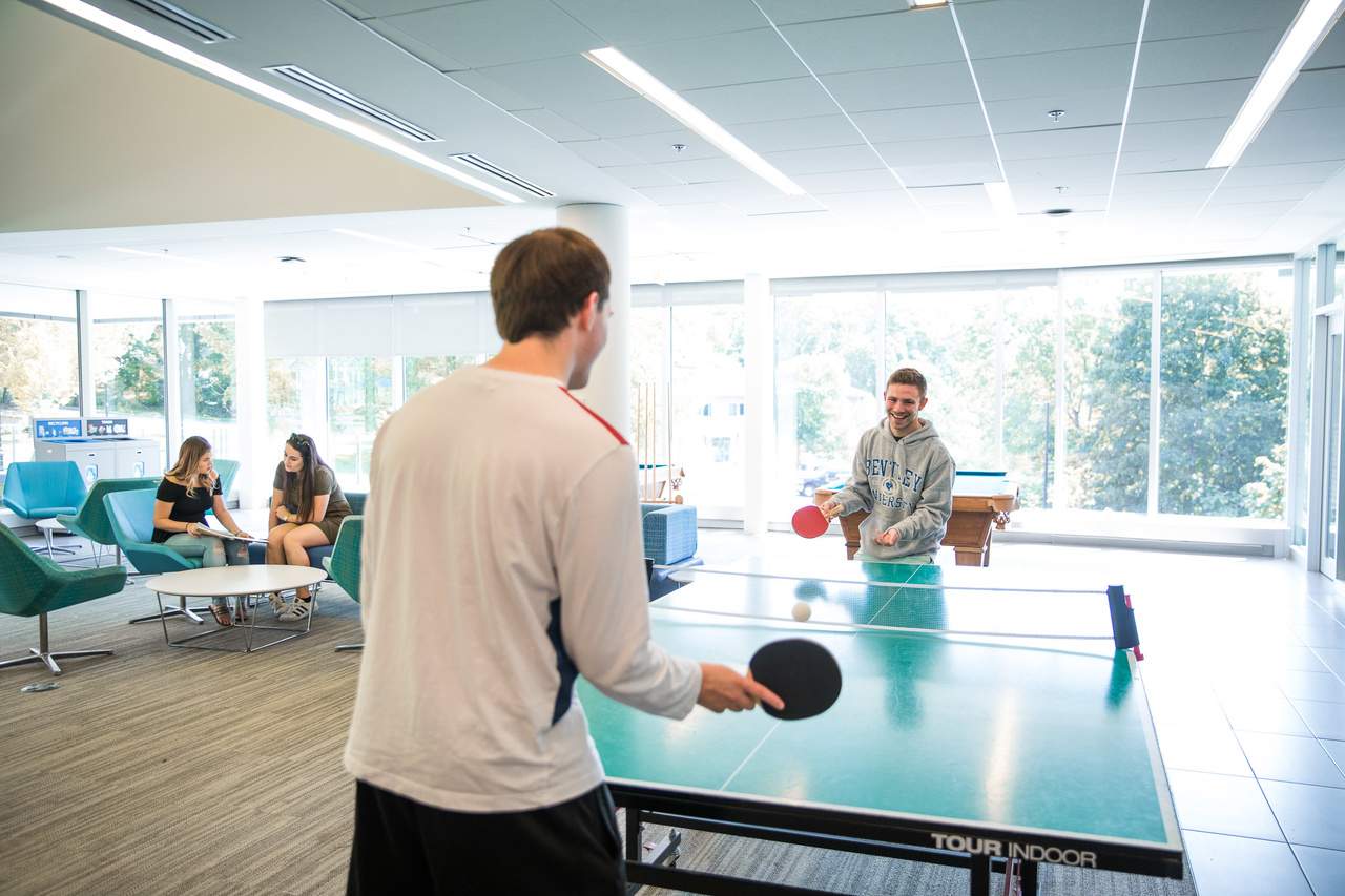 two male students playing ping pong