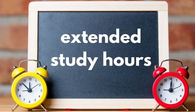 chalkboard with writing on it 'extended study hours' flanked by two alarm clocks