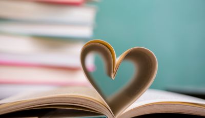 opened book with pages folded into a heart shape