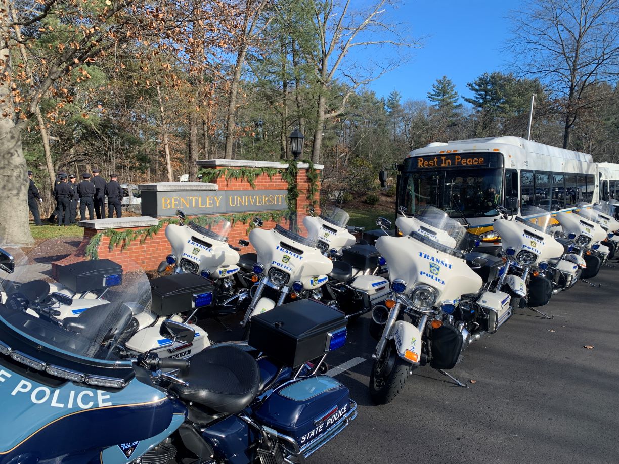 Police motorcycles and city buses near Bentley University entrance
