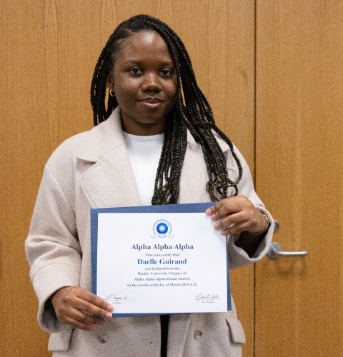 Daelle Guirand ’25 displays her Tri-Alpha certificate.