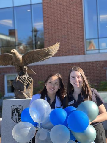 Graduate Admission Officers Danielle and Meili holding balloons welcoming students to preview day