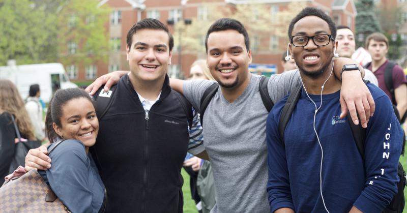 students smile together at an event on campus