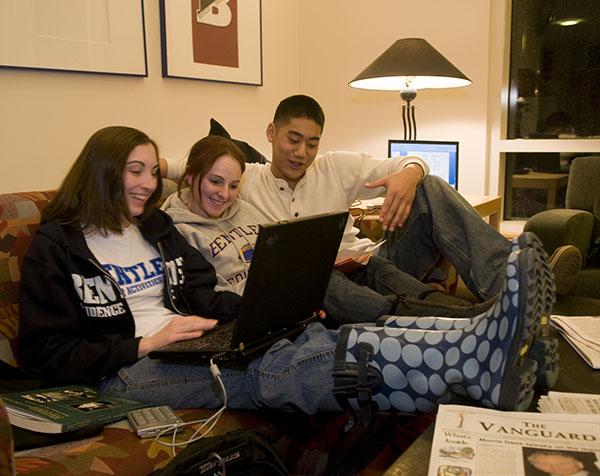 Students doing work on a couch