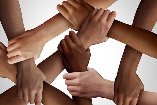 people of different ethnicity holding hands together as a social solidarity concept of a multiracial group working as united partners.