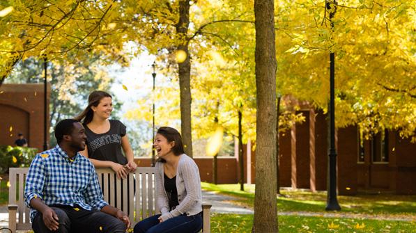 three students sitting on campus together