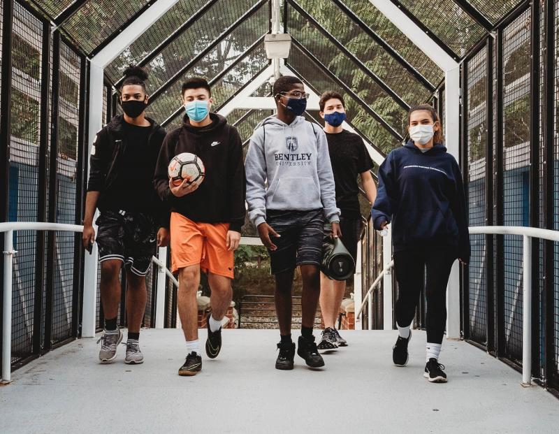 Bentley students on the footbridge in masks