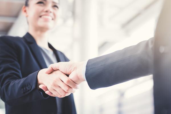women business leader shaking hands with partner 