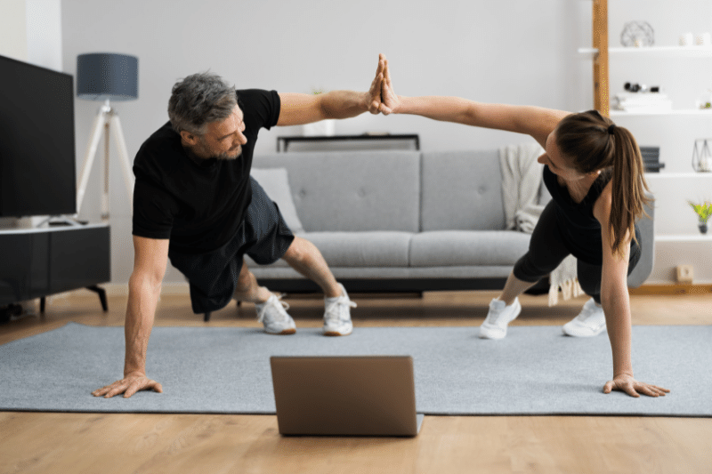 Man and woman high five during home workout
