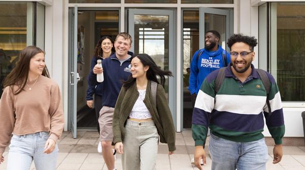 five students walk together on campus 