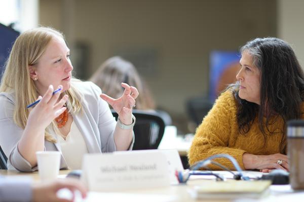 two mba program students work together at a table 