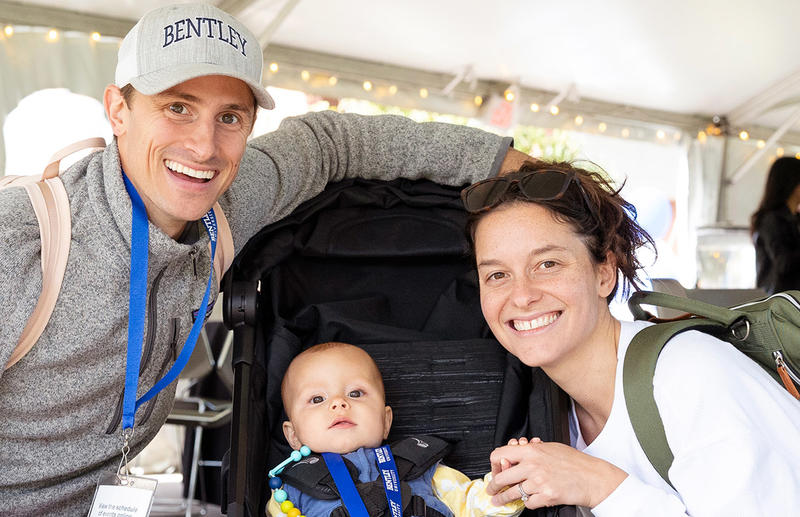 A family smiles with a baby on Falcon Weekend
